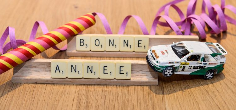 Vroum, vroum direction 2023 ! Bonne année écrit avec des lettres de scrabbles avec une petite voiture en jouet